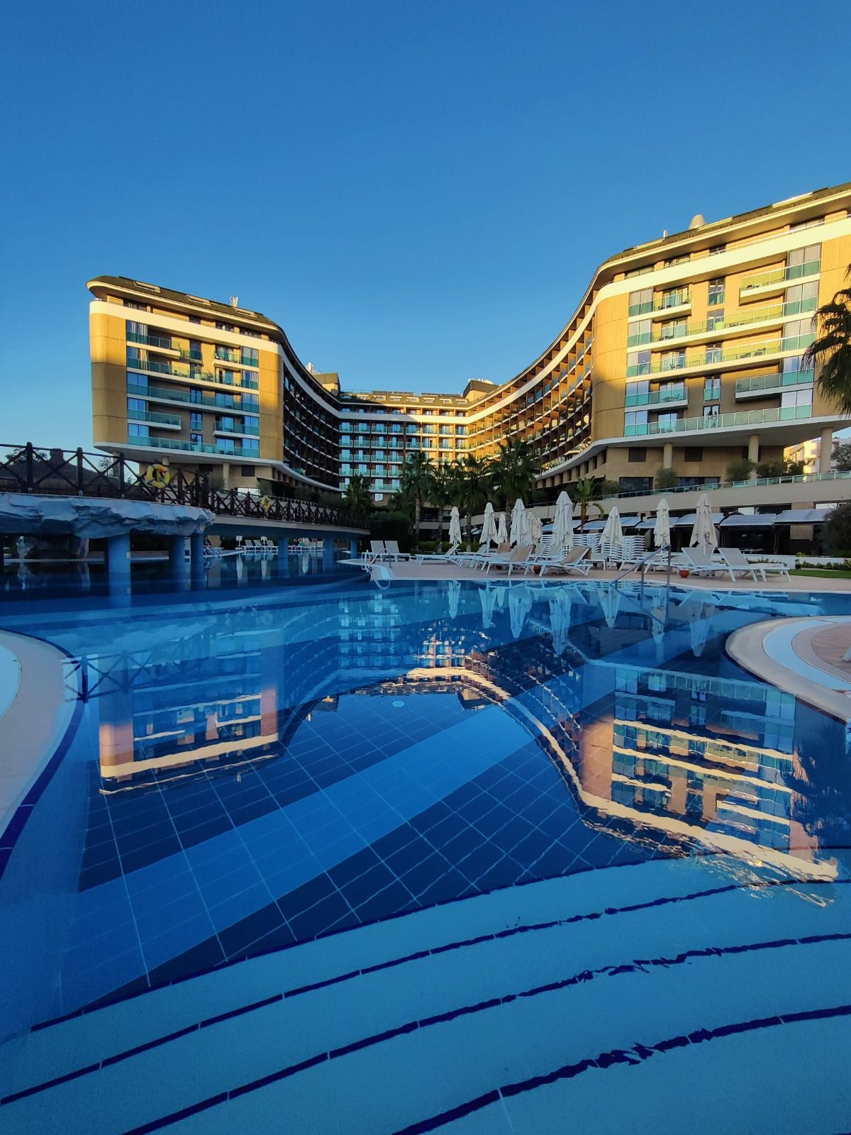 Luxury hotel reflected in a still pool at dusk