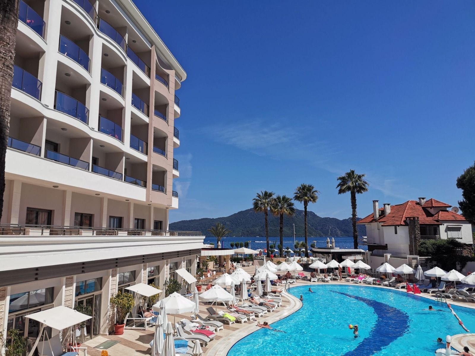 Hotel balconies above a pool beside the sea in Turkey