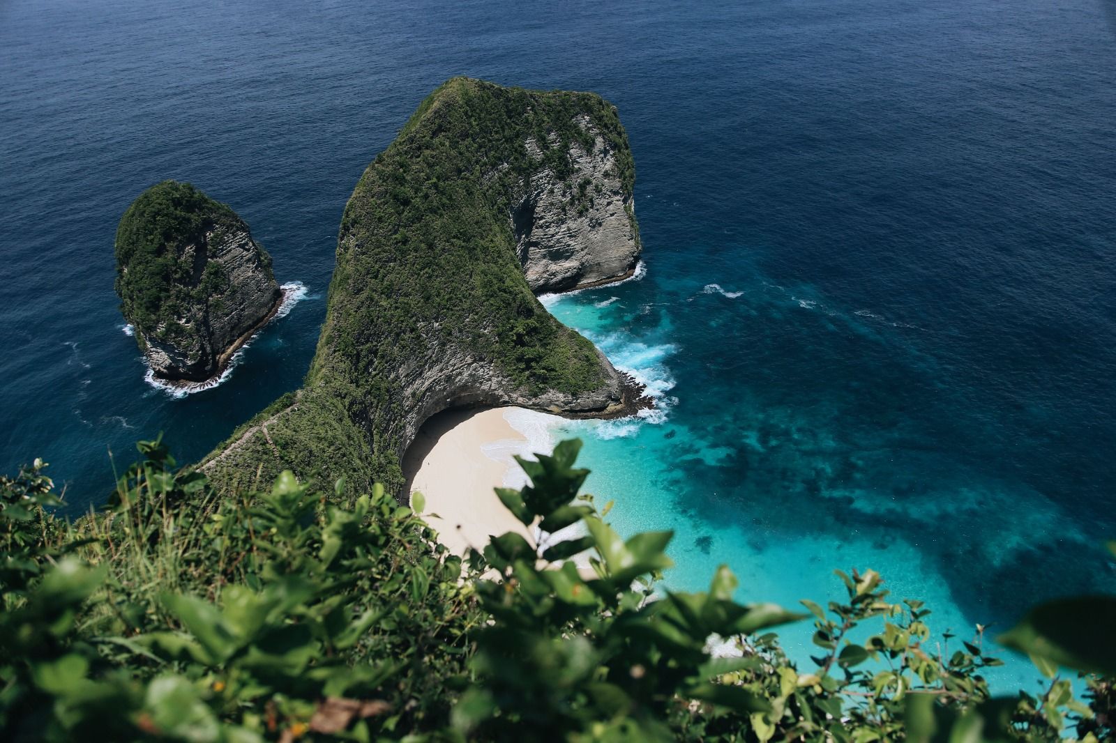 Hidden white sand cove between green cliffs