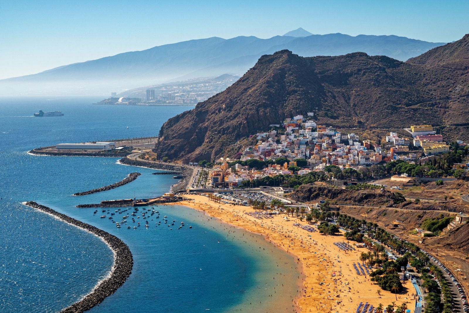 Crescent-shaped golden beach and hillside town on the Turkish coast